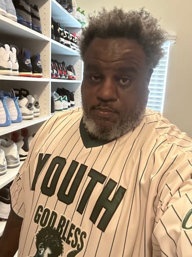 Reviewer wearing a custom cream and green stripe pullover baseball jersey with 'YOUTH GOD BLESS' on the front.