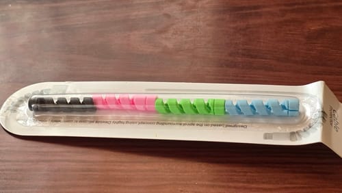 Customer's multi-colored spiral Cable Protector Set inside its original packaging on a wooden surface.