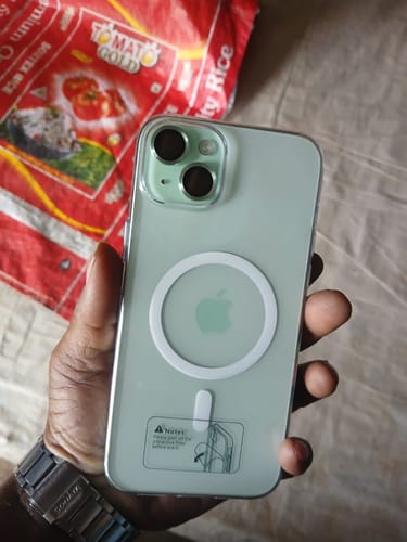 Customer holding a light green phone in a clear case with a visible white charging ring.