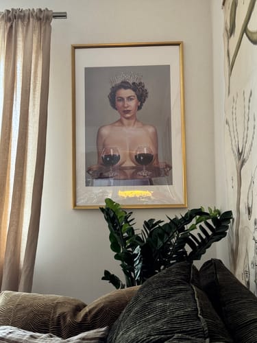 Customer's 'Majestic' art print in a gold frame, hanging on a wall above a houseplant.