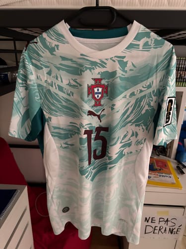 Client montrant le maillot extérieur du Portugal, avec le numéro 15 floqué sur le devant.