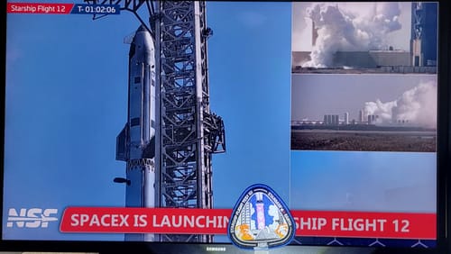 Customer's Starship Flight 12 Collectors Patch in front of a screen showing the live rocket launch broadcast.