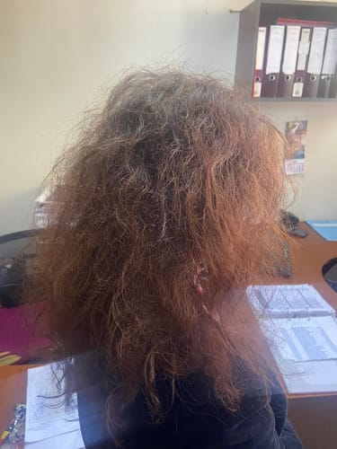 Una clienta muestra su cabello cobrizo y voluminoso tras usar la Infusión Hibisco.