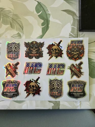 Un client montre la feuille du pack de stickers, qui présente plusieurs autocollants holographiques de style motard.