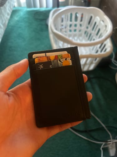 Customer holding the slim 80Eighty® Black Leather Wallet in hand, with several cards visible.