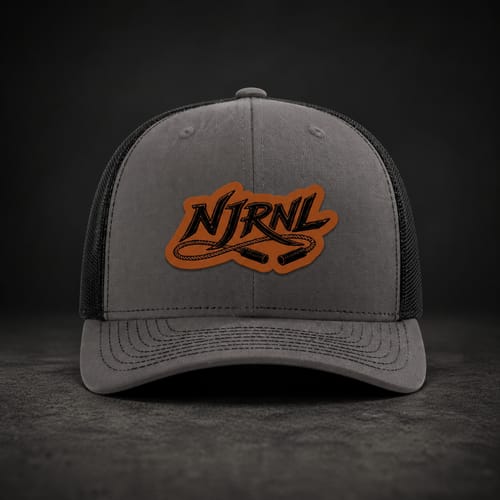 Reviewer's grey and black Custom Leather Patch Trucker Hat with a brown leather patch featuring a 'NJRNL' jump rope logo.