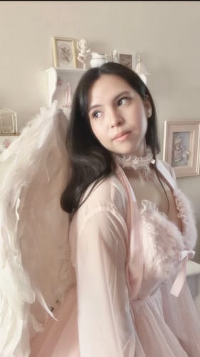 Reviewer looks over their shoulder wearing the pink Rosé Princess Fur Chiffon Robe with its soft fur trim.