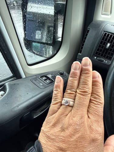 Customer wearing the light-colored Round Cut CZ Silicone Ring Set on their hand inside a vehicle.
