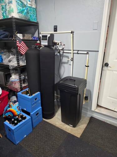 Customer's black SoftPro® Elite HE Water Softener system installed and operating in a utility room.