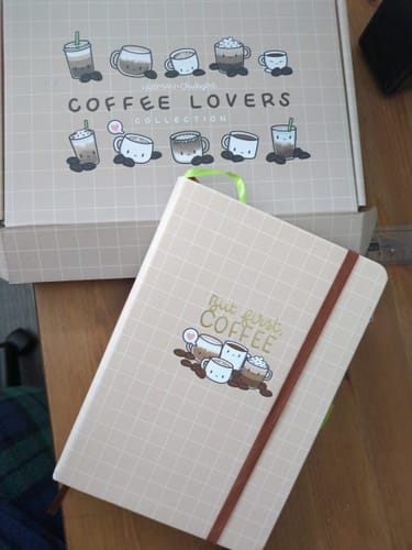 Customer's Coffee Lovers dot-grid journal and collection box from the set, placed on a wooden table.