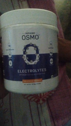 Customer holding the OSMO Electrolyte Hydration Blend tub in Valencia Orange flavor.