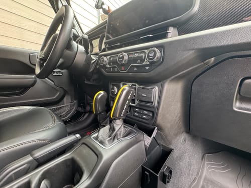 Reviewer's custom yellow and black CMM Offroad Shifter Package installed in a Jeep's center console.