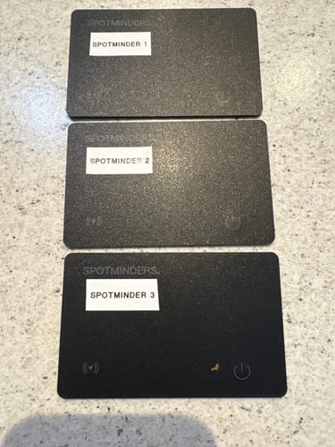 Reviewer's three black SPOTMINDERS tracking cards lined up on a counter, labeled one, two, and three.