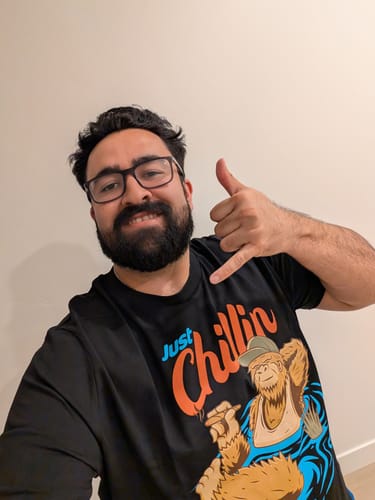 Reviewer smiling in a black graphic t-shirt with 'Just Chillin' text from the TCG95 MYSTERY CASH BOX.