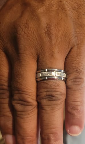 A customer's hand wearing the silver-toned Cassian ring, showing the channel of small zircon stones.