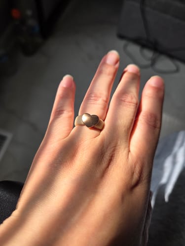 Customer's hand wearing the Heart Collection silicone ring with a shiny metal heart.