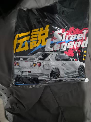 Customer's black STREET LEGEND TEE in its original packaging, showing the car graphic.