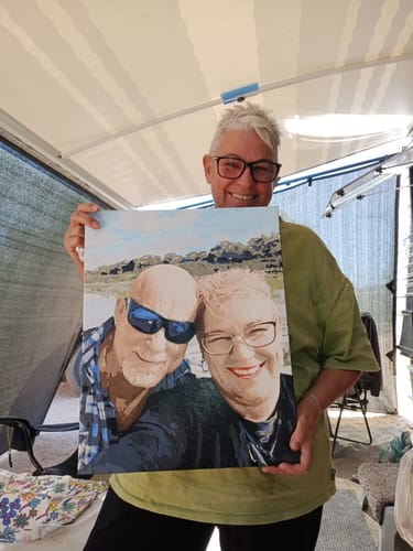 Reviewer smiling while holding up their finished Custom Paint by Numbers Kit, which shows a portrait of a couple.