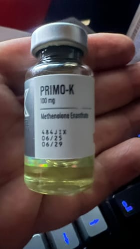 Cliente sosteniendo en la mano un vial de PRIMO-K que muestra su líquido amarillento.