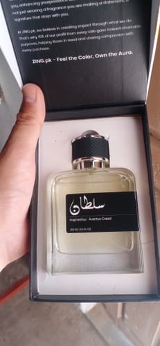 A customer holds the open box revealing the square glass bottle of Sultan perfume.