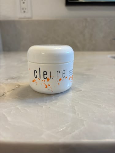 Reviewer's white jar of Hydrating Daily Face Cream sitting on a bathroom counter.
