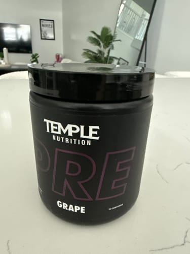 Customer's black tub of Temple Pre Workout in Grape flavor on a white countertop.