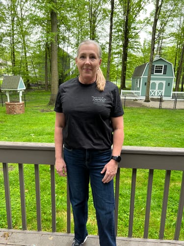 Customer standing outdoors wearing the front of the black MYSTERY TEE.