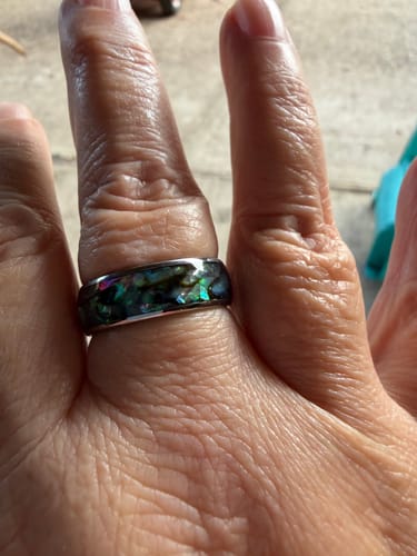 Close-up of a customer wearing the Nerium ring, showing its iridescent abalone shell inlay.