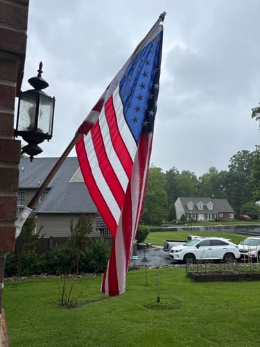 Customer's Heavy Duty American Nylon Flag hanging from a flagpole on the side of a house.