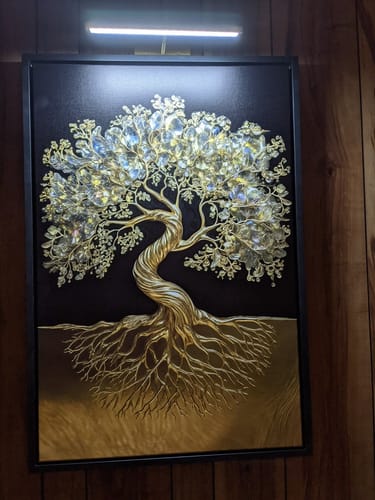 Customer's golden 3D Tree of Life Wall Art with crystal leaves, illuminated on a wood wall.