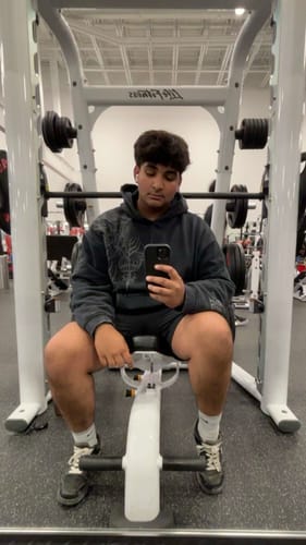 Customer at the gym taking a selfie in the oversized graphic Cyberpunk Hoodie.