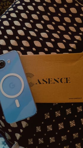 Customer's light blue phone, with the UltraShield Tempered Glass applied, shown next to the cardboard product packaging.