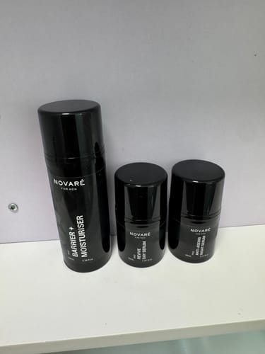 Customer's skincare products from the CORE FOUR HYDRATE BUNDLE in sleek black bottles on a shelf.