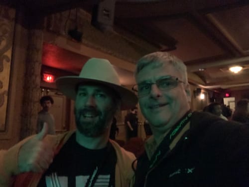 Reviewer wearing a SpaceX lanyard takes a selfie with another person at an event.
