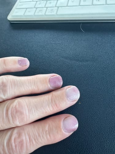 Customer's hand showing their nails with sparkly Cosmic Stardust gels after one week of wear.