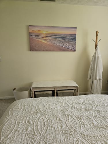 Customer's Abstract Beach Shore V canvas hanging on a bedroom wall above a small bench.