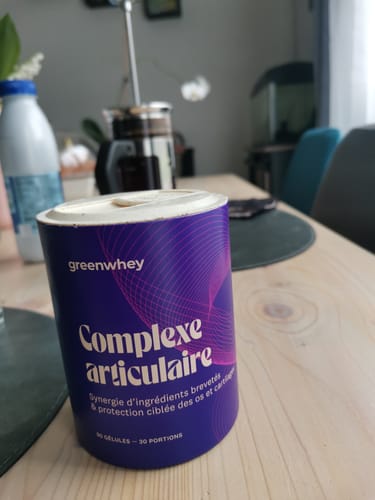 Le pot violet de Complexe Articulaire d'un client, posé sur une table en bois.