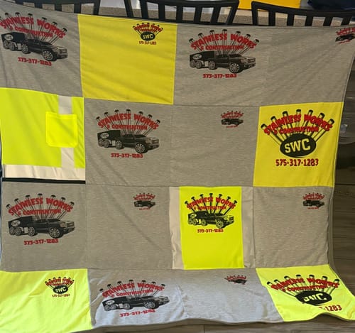 A customer's Project Repat T-Shirt Quilt made from grey and neon yellow work shirts with a company logo.