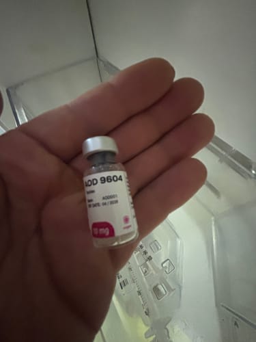Cliente sosteniendo en la mano un frasco del péptido AOD 9604 de 10 mg.