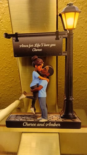 Customer's personalized wooden plaque showing a cartoon couple kissing under a lamppost, customized with the names 'Choree and Amber'.