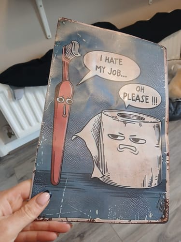Customer holding the 'I Hate My Job' funny wall art, showing the full design.