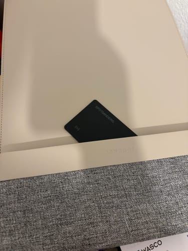 Customer's black SPOTMINDERS. Tracking Card partially inserted into a light-colored laptop sleeve.