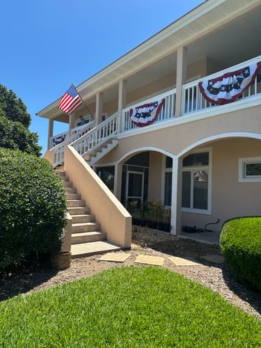 Reviewer's home decorated with Americana Pleated Fans with Stars along an upper balcony.