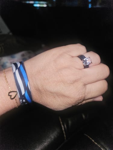 Customer wearing the black silicone ring with a large oval CZ, alongside a thin blue line bracelet.