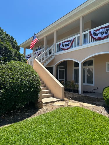 Customer's Americana Pleated Fans with Stars decorating the railing of a sunny second-story balcony.