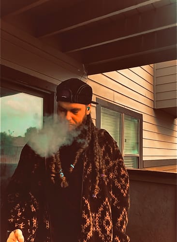 Reviewer wearing the black Big Camp Hat backwards on an outdoor balcony.