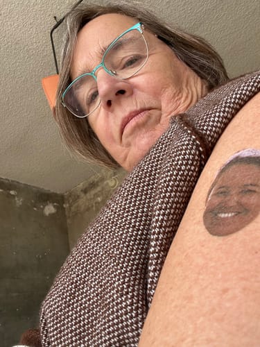 Reviewer showing a Custom Photo Face Temporary Tattoo of a smiling person applied to their arm.