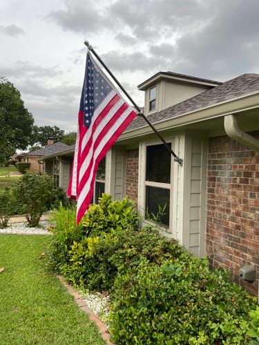 Customer photo showing an American flag mounted on the front of a home.
