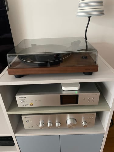 Customer's TT-3 PLUS turntable with a wood base, set up on a white shelf above other audio components.