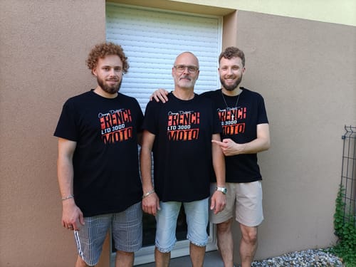 Un client et ses deux fils portant des t-shirts noirs assortis de la COLLECTION ORANGE DISTRICT.